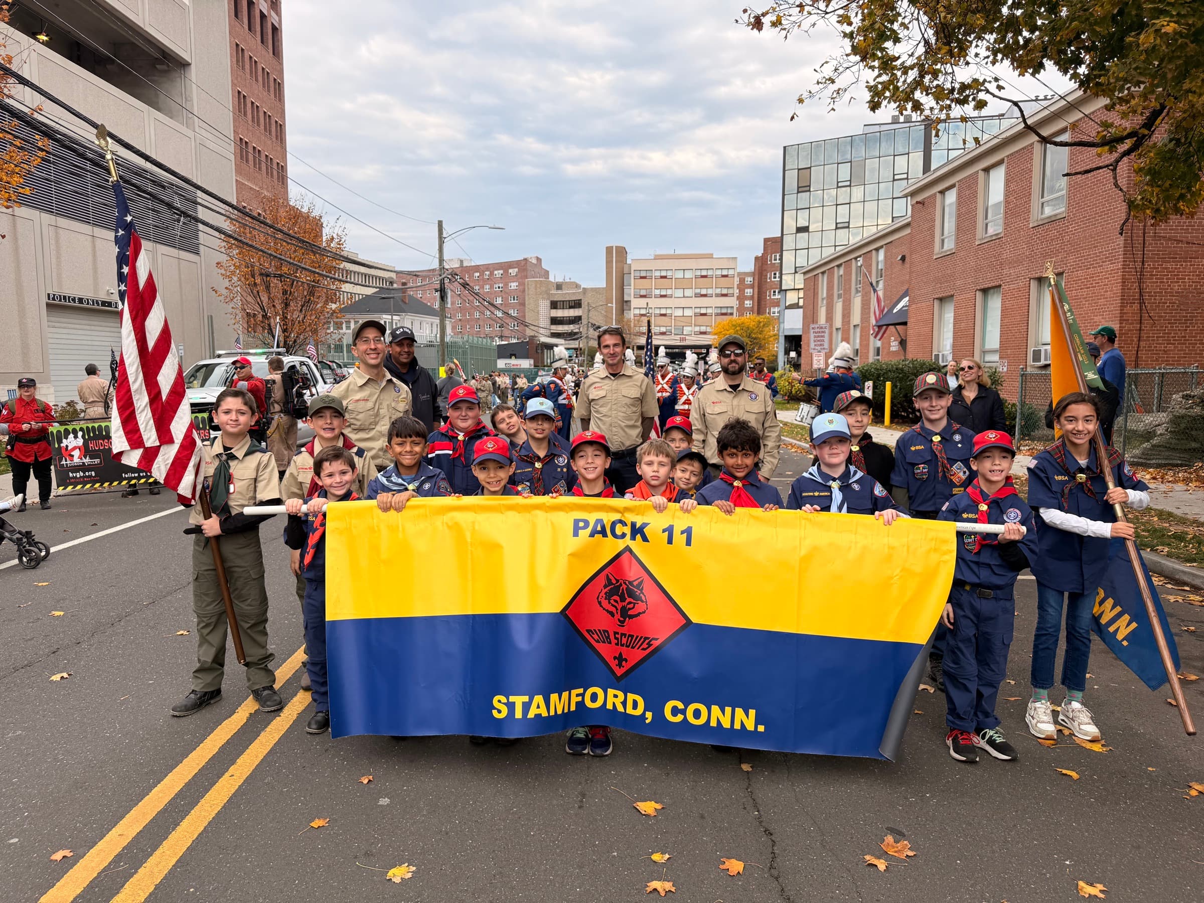 Cub Scout Pack 11 marching in a Stamford parade behind their pack banner