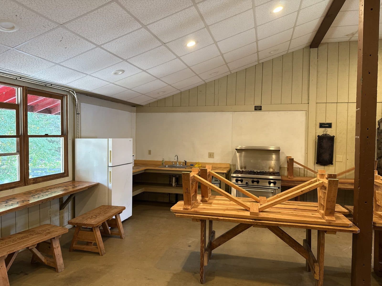The kitchen in Loomis Hall, with a gas range, refrigerator, sink and a wooden table